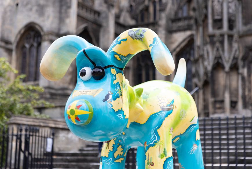a statue of Gromit painted with an eye patch and a map of the west of england